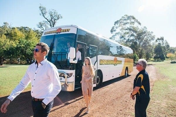 Wedding guests stepping down from a Horizons West coach, the driver waiting beside the door